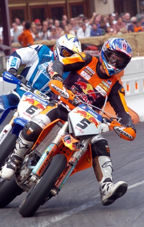 SuMo 2 The biggest crowd ever to watch a Supermoto race was here at Reno in 2005. Here Jurgen Kunzel and Mark Burkhart battle in that event. Note the crowd in the background. (Larry Lawrence photo)