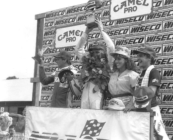 Kevin Schwantz is smothered by his laurel as he celebrates his 1987 Mid-Ohio Superbike victory. Joining Schwantz on the podium is eventual series champ Wayne Rainey (left) and third-place finisher Jimmy Filice (right). (Larry Lawrence photo)