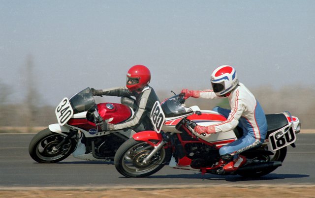 Schilling & Dutton - Talladega - Feb 1986 - sm Thebaut Dutton (180) and Eric Schilling (340) race side by side through a turn at Talladega Grand Prix Raceway in February of 1986. Dutton on a Yamaha RZ350 and Schilling on a Honda Interceptor 500, were well matched on the twisty Talladega circuit. This was a WERA C Production race and Dutton came out on top in this battle. (Larry Lawrence photo)