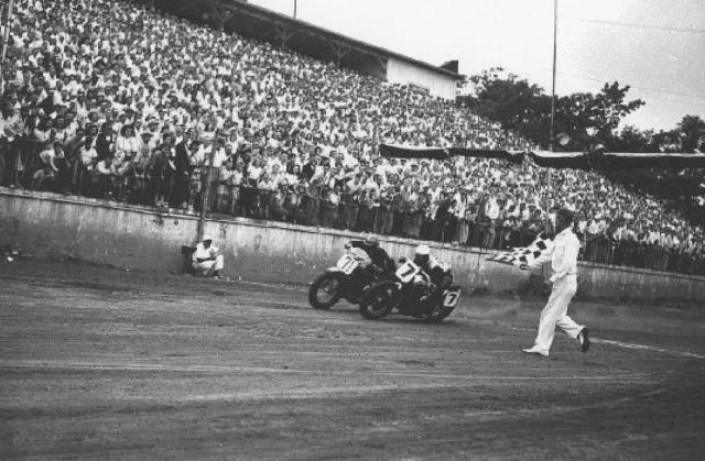 Billy Huber (7) drafts underneath Bobby Hill (71) as the two cross the finish line. Officials couldn't decide who won, so they called the race a tie - the only one in AMA National history. High-speed cameras started being used shortly after this race.