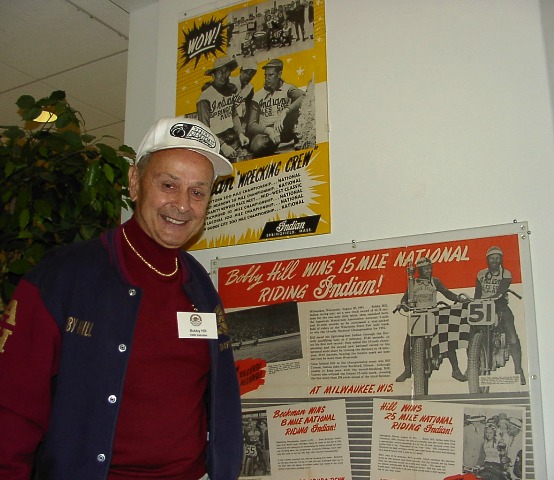 Two-time AMA National Champion Bobby Hill, in October of 2002 during an induction weekend, standing next to a display at the Motorcycle Hall of Fame with memorabilia from his illustrious racing career. (Larry Lawrence photo)