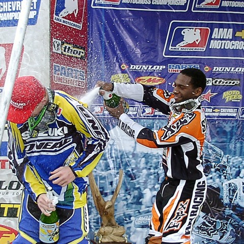 Mt. Morris 2004 - 125podium James Stewart, of Haines City, Fla., sprays fellow competitor Broc Hepler with champagne on the podium of the AMA Chevrolet Motocross Championship race on May 30, 2004 at High Point Raceway in Mt. Morris, Pa. Stewart broke through to win his first race in Mt. Morris. Local favorite Hepler, from nearby Kittanning, Pa., was second in Sunday’s 125cc race. (Larry Lawrence photo)
