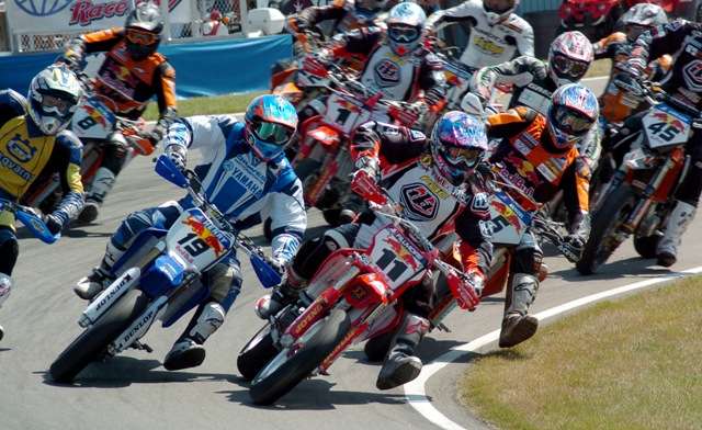 Shawano SuMo '05 start Chris Fillmore, of Oxford, Mich., has the inside line on his Troy Lee Designs Honda at the start of race one at the July 2005 AMA Supermoto Championship race in Shawano, Wis. Doug Henry, of Torrington, Conn., took the lead from Fillmore on lap six and went on to win both races on his Graves Motorsports Yamaha. At the time Henry also gained the series points lead after four of 10 rounds. (Larry Lawrence photo)