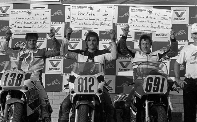 Wilson, Thomas - GNF90 Metzeler paid contingency bucks to riders who raced with their tires at the 1990 WERA Grand National Finals. Here are the money winners from that year’s A Production Novice class. Thomas Wilson (No. 691) was the big winner, scoring $250 for his victory in the class. Dale Baker (No. 812) was third and Gordon Miller (No. 138) fifth. Garry Gallagher, who administered the Metzeler program, can be seen slightly cut off on the far right. (Larry Lawrence photo)