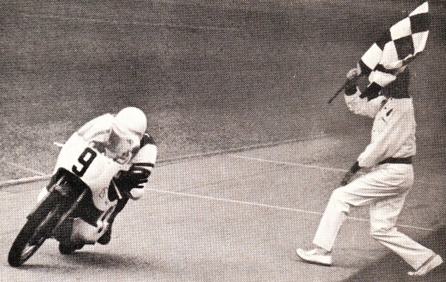 Gary Nixon takes the winning checkered flag from AMA Starter Duke Pennell at the 1967 Daytona 100-Mile Lightweight race.