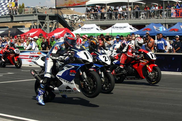 Laguna '06 Superbike start Ben Spies wheelies his Yoshimura Suzuki at the start of the AMA Superbike Championship race at Mazda Raceway Laguna Seca on Saturday, July 22, 2006, in Monterey, Calif. Spies took the victory, his eighth of the season, by a margin of 3.114-seconds over Tommy Hayden. You can also see Aaron Yates (No. 20), Miguel Duhamel (No. 17), Mat Mladin (behind Duhamel) and Jake Zemke (No. 98). (Riles & Nelson photo)