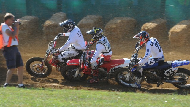 Stu at Peoria Mike “Stu” Stuhler, of Stu’s Shots, is literally on top of the action during the Peoria TT National as Brad Baker, JD Beach and Jeffrey Carver race in close quarters into turn two. (Larry Lawrence photo)