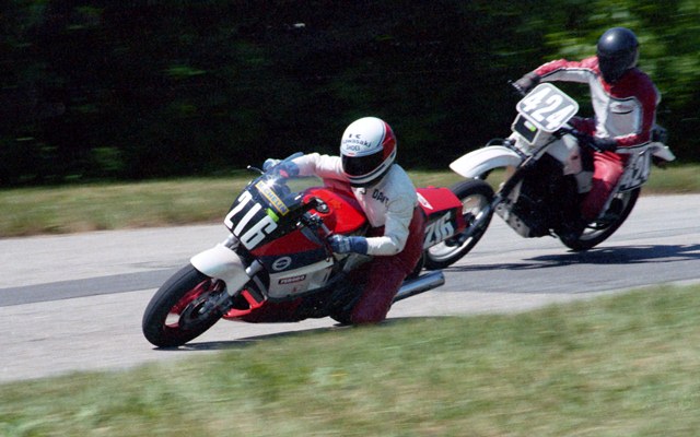 David Meyer (No. 216), on his Kawasaki Ninja 600, blitzes an unidentified dual sport rider in a WERA road race at Grattan sometime in the mid-to-late 1980s. It looks like the dual sport guys still has his rear fender tool kit attached. Ready for anything I suppose. (Larry Lawrence photo)