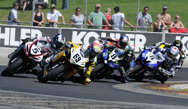 Eslick - Elkhart '11 Danny Eslick (No. 69 Geico Suzuki) leads Dane Westby (No. 5 M4 Suzuki), Josh Herrin (No. 8 Monster Energy Graves Yamaha), Tommy Aquino (No. 6 Pat Clark Sports, Graves Motorsports Yamaha) and several other riders in the Sunday Daytona SportBike at Road America in June of 2011. (Larry Lawrence photo)
