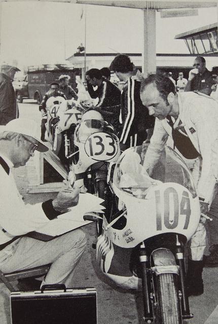 Guttner, Dieter - Daytona '71-sm Dieter Guttner stands next to what is probably a Yamaha TD2 as he goes through tech inspection at Daytona in 1971. Behind Guttner is the No. 133 of Everett Strawn, No. 75 Thomas Bovaird and possibly No. 44 John Moyer. (Courtesy DIS)