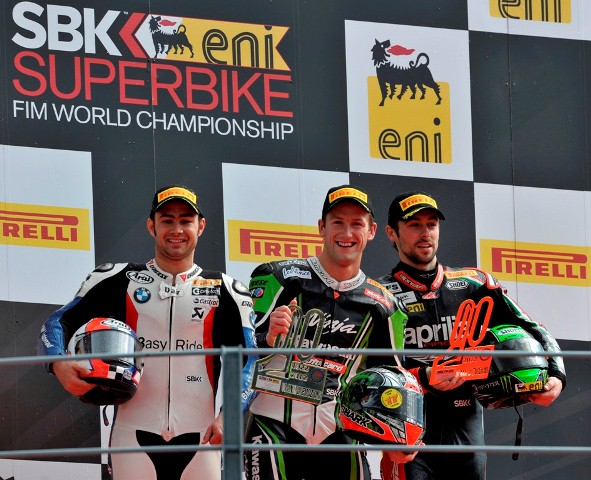 Sunday_Race2_podium-sm On a day of uncertainties and unpredictable track conditions Tom Sykes (Kawasaki Racing Team) provided an emphatic win out of all proportion to the short eight laps the race lasted before the rains came back to spoil the party yet again. His margin of victory was 9.709 seconds, more than a second per lap faster than his main rivals in damp but drying track conditions.