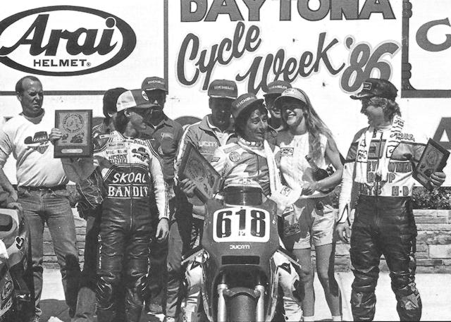 Daytona BOTT podium '86 Marco Lucchinelli (center) celebrates his victory in the 1986 Daytona Pro Twins (Battle of the Twins) race. He won over Cosworth mounted Paul Lewis (left) and Harley-Davidson’s Gene Church (right). (Courtesy DIS)