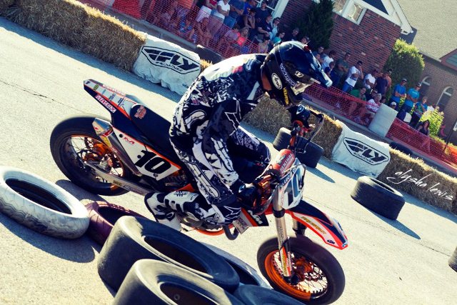 Pro Winner Johnny Lewis - Taco Bell Ogemaw Hills Supermoto Spectacular - 07202012-02 (Photo Alysha Lewis)-sm The last time Johnny Lewis threw a leg over a supermoto race bike was May 2009 in Las Vegas. On Friday, July 20 at the Taco Bell Ogemaw Hills Supermoto Spectacular, he was impressive in his return to the unique racing discipline of asphalt and dirt on a temporary course in downtown West Branch, Mich. Lewis convincingly won both pro main events on a Van Way Racing KTM 450SMR in front of thousands of spectators who lined the sidewalks and streets. (Photo Alysha Lewis)