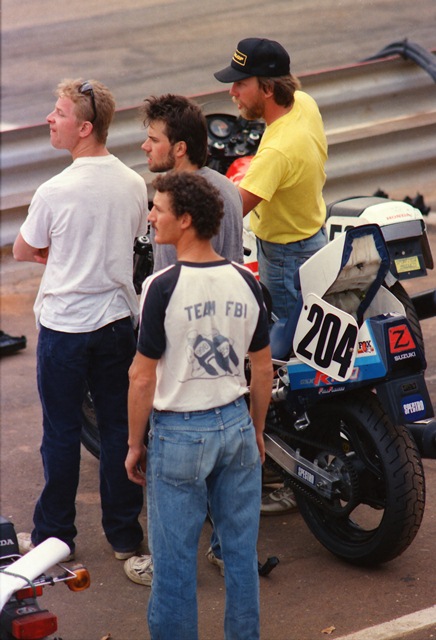 Zampach - GNF 1987 Scott Zampach (center, in gray shirt), along with some of his crew and fellow racers, watch a race at the 1987 WERA Grand National Final at Road Atlanta. Zampach was a first-year expert that year and on hand at the GNF to race in the lucrative Suzuki GSXR Cup Finals. (Greg Sickmeier photo)