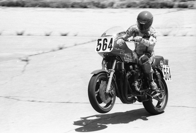 Burroughs, Dale - Mid-America '84 Dale Burroughs wheelies the Po’ Folks Kawasaki out of turn one of Mid-America Raceway during a WERA National Endurance race in July of 1984. Team Po’ Folks was a leading WERA and AMA/CCS National Endurance team in 1984. (Larry Lawrence photo)