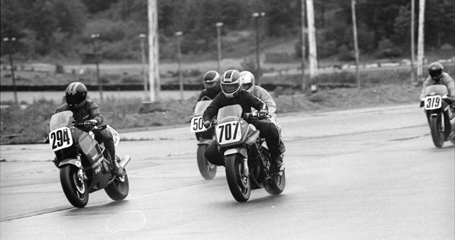 Paul Sharwell (No. 294) and Chris Hughes (No. 707) race side by side for the first turn at the start of a WERA sprint race in July of 1986 at Bryar Motorsports Park in Loudon, New Hampshire. Another rider in the shot is Brian Sobolewski (No. 319). Hughes, a master rain rider, won the race. (Larry Lawrence photo)