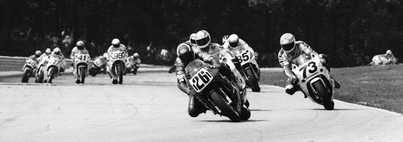 Jimmy Adamo, riding a Ducati Superbike, leads a big pack into Road America’s turn seven during the AMA Superbike race there in June of 1990. (Larry Lawrence photo)