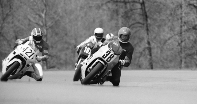 In this 1987 photo of Dave Barnard leading Fritz Kling I honestly have no idea which corner of the Grattan circuit this is. Another mystery is the bike is Barnard is on. It almost looks maybe like a Yamaha RZ500. Kling is on a Honda Hurricane. If that is in fact an RZ500 Barnard is racing, what an interesting matchup against the Hurricane. (Larry Lawrence photo)