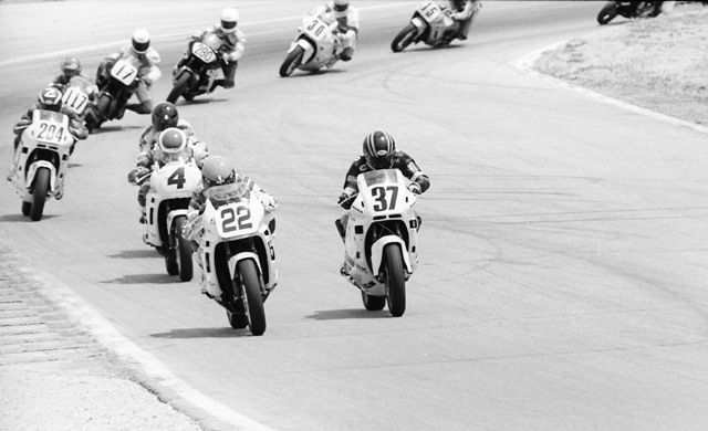Russell - Ashmead Scott Russell (No. 22) and John Ashmead (No. 37) battle side by side at Road America in June of 1988 during the AMA 600 Supersport final. Behind the leaders in this shot are David Sadowski (No. 4), Polen, Zampach (No. 204), unknown rider (No. 117), John Eidenberger (No. 17), Britt Turkington (No. 280), Morgan Murphy (No. 30) and Russ Paulk (No. 15). Polen won over Ashmead and Zampach. (Larry Lawrence photo)