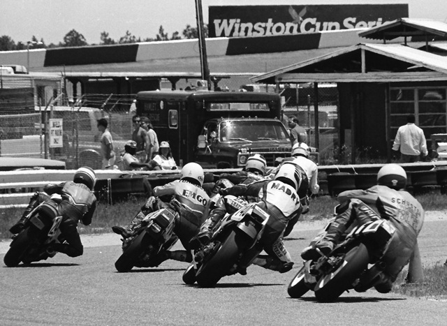 Rockingham WERA Endurance 1988 A group of riders race bar to bar through the infield at Rockingham during a WERA National Endurance race in May of 1988. Bringing up the rear is Red Stripe Racing’s Brent Schuster, then John Madry (unknown team), Rabbit Racing’s Britt Turkington, Dave Schmidt of Team Indy, and two other riders up front. (Larry Lawrence photo)