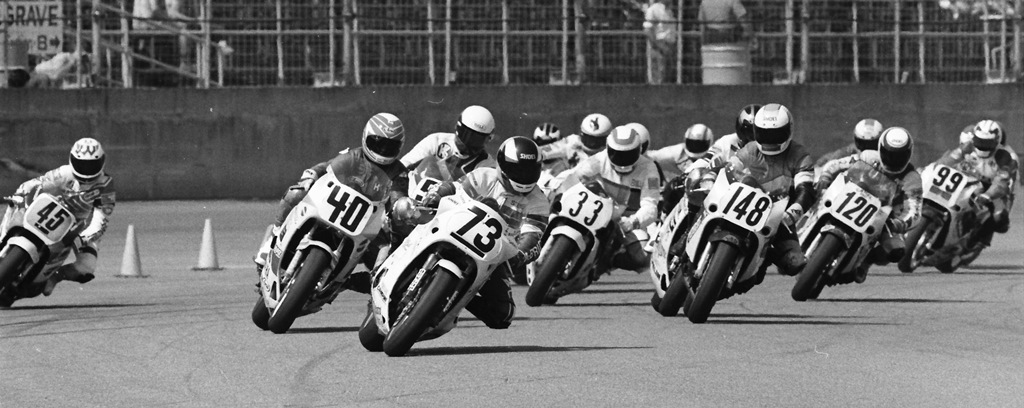 Steve Crevier (No. 73) on a Team Ciampini Suzuki GSXR750, leads a group of riders through the first turn in the 1989 Daytona 200 by Arai. Racing behind Crevier are (from right) James Whitham (No. 45), Kurt Hall (No. 40), Bill Loomis (No. 33), Tim Ledbetter (No. 148), Paul Ziechang (No. 120) and David Smith (No. 99). (Larry Lawrence photo)