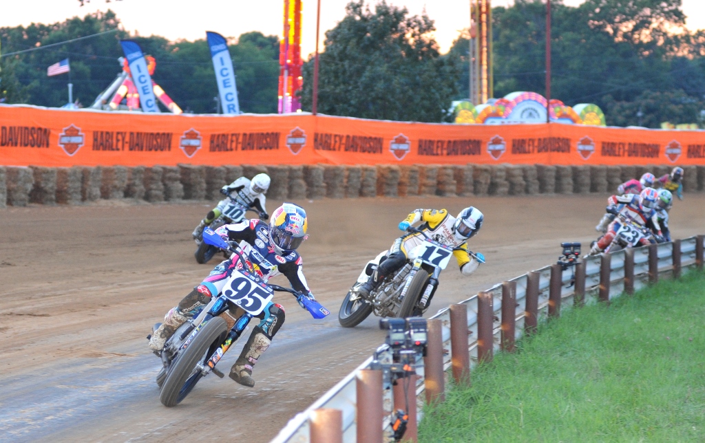 JD Beach on the No. 95 Burnett Farms Racing/Red Bull Kawasaki EX650, leads Lloyd Brothers Harley-Davidson mounted Henry Wiles (No. 17), Latus Motor Triumph’s Johnny Lewis (No. 10) and Kiesow Racing Harley-Davidson mounted Jeffrey Carver (No. 23) during a Heat race at the 2013 Indy Mile. The race, held during the Indiana State Fair, you can see some of the rides lit up in the background. (Larry Lawrence photo)