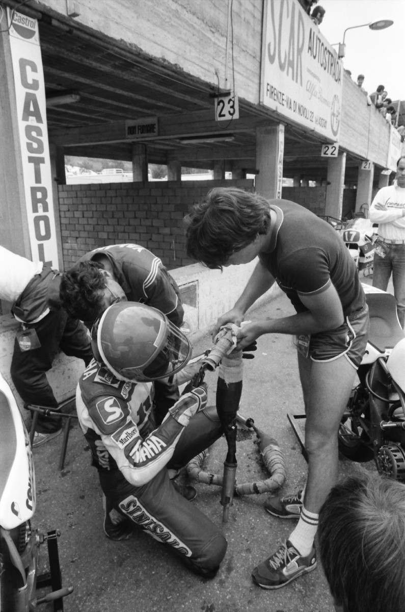 Things have changed quite a bit in Motorcycle Grand Prix racing in recent decades. In the 1980s it wasn’t all that uncommon to see a GP rider pitch in and help with the wrenching, as GP rider Martin Wimmer illustrates in this photo by the legendary Henny Ray Abrams, taken at Mugello in May of 1985. Keep in mind Wimmer was coming off a 250 Grand Prix victory in his home GP in Germany one week earlier. (Henny Ray Abrams photo)