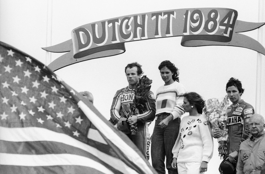 Photographer Henny Ray Abrams’ photo of the podium at the 1984 Dutch TT - Randy Mamola has just won the race (with Eddie Lawson on the podium in third). Henny saw an American flag, worked out in his mind the shot and got into position and captured this amazing shot of Mamola and Lawson at attention during the playing of the National Anthem with the flag waving in the foreground. (Henny Ray Abrams photo)