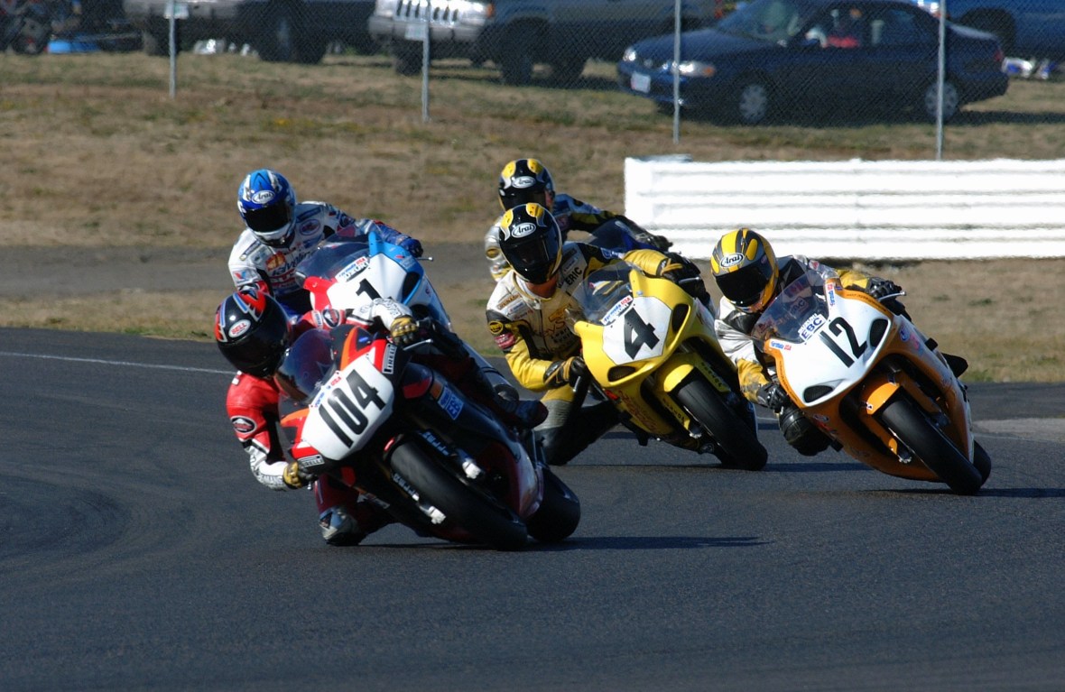 Michael Himmelsbach, riding an Aprilia RSV1000 Mille R, leads a group of riders in the NRRS Lockhart Phillips Unlimited Superbike race one at Portland International Raceway in September of 2001. Trailing Himmelsbach is Alan Schmidt (No. 12), Eric Wood (No. 4), Grant Lopez (No. 1) and another unidentified rider. (Henny Abrams photo)